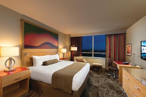 a hotel room with a large bed and a television at River Rock Casino Hotel in Richmond