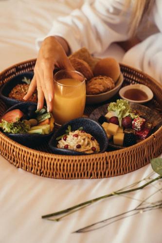 a tray of food on a table with a person holding a drink at Cloud 7 Residence AlUla in AlUla