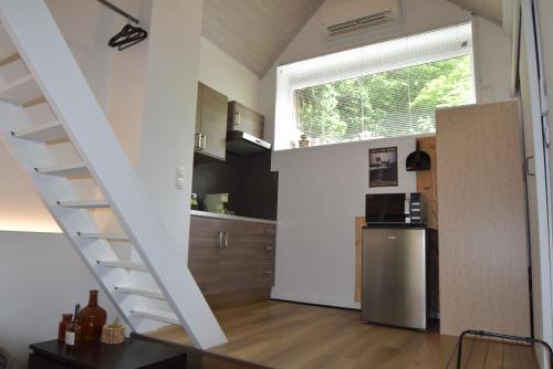 a kitchen with a staircase leading into a kitchen with a refrigerator at Kibbelschuur in Zottegem