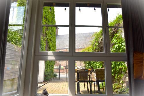 a window view of a patio with a cat looking out at Kibbelschuur in Zottegem