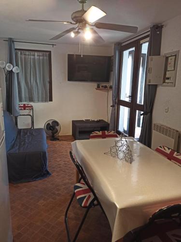 - un salon avec une table et un ventilateur de plafond dans l'établissement Résidence Sable 4 appartement 5 pers 100 m de la plage, à Leucate