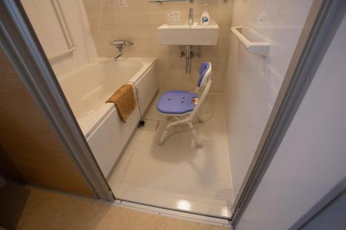a small bathroom with a bath tub and a sink at Family Stay Tsukuba Room in Tsukuba