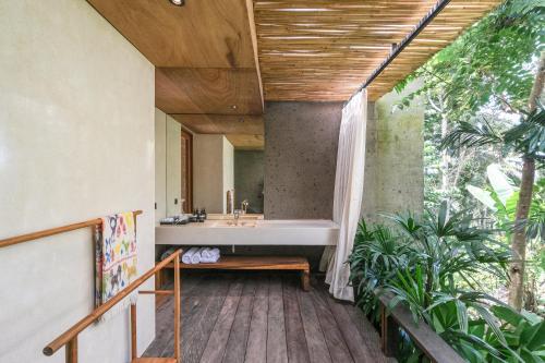 a bathroom with a tub and a sink at Rumah Subak Tampaksiring in Tampaksiring