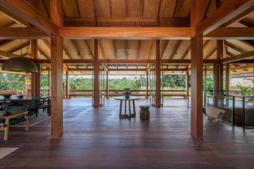 a large room with wooden ceilings and a wooden floor at Rumah Subak Tampaksiring in Tampaksiring