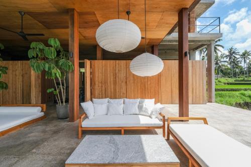 a living room with two beds and a couch at Rumah Subak Tampaksiring in Tampaksiring