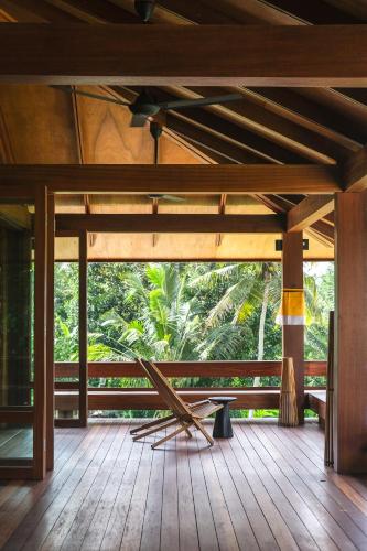 a room with a wooden floor and a large window at Rumah Subak Tampaksiring in Tampaksiring