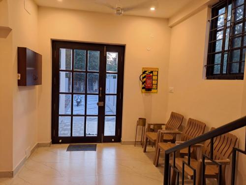 a room with a door with chairs and a table at The Heritage Inn in Nāgore
