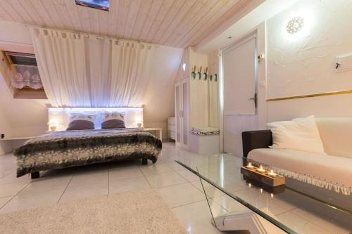 une chambre avec un lit et une table en verre dans l'établissement Logement de charme proche Colmar avec terrasse, à Sainte-Croix-en-Plaine