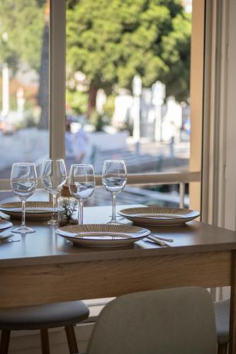 - une table avec des verres à vin et des assiettes dans l'établissement La Chic Riviera - Clim - Wifi - Croisette, à Cannes