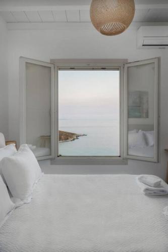 a bedroom with a large window with a view of the ocean at Infinity View Villa Agios Ioannis Serifos in Serifos Chora