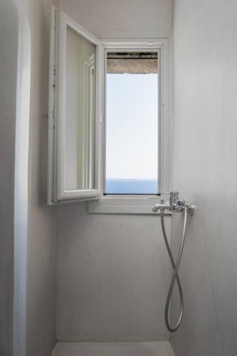 a shower in a bathroom with a window at Infinity View Villa Agios Ioannis Serifos in Serifos Chora