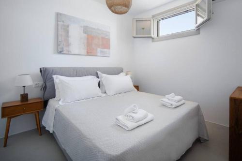 a bedroom with a bed with two towels on it at Infinity View Villa Agios Ioannis Serifos in Serifos Chora