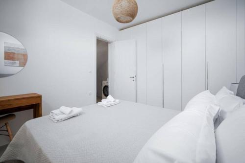 a white bedroom with a bed with towels on it at Infinity View Villa Agios Ioannis Serifos in Serifos Chora