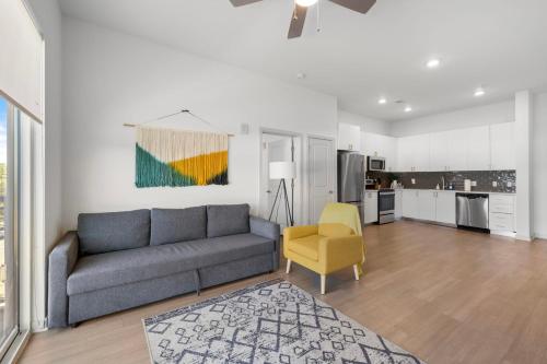 a living room with a couch and a yellow chair at Modern Nulu 2BR CozySuites 02 in Louisville