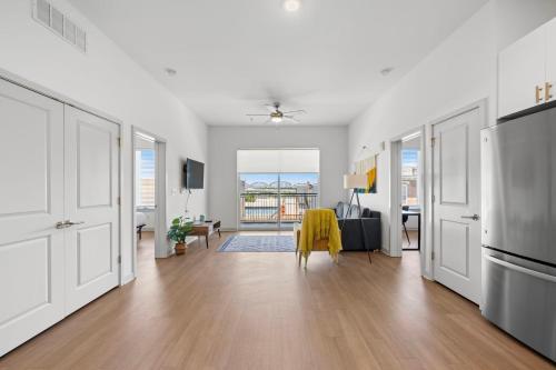 a white living room with a table and a kitchen at Modern Nulu 2BR CozySuites 02 in Louisville