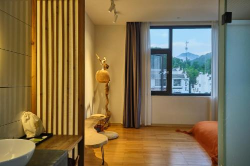 uma casa de banho com uma cama, um lavatório e uma janela em Nature Cure Village Lodge-婺源自在舍 em Wuyuan