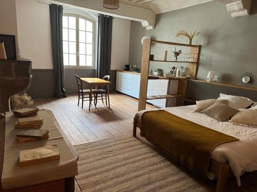 a bedroom with a bed and a table and a dining room at La Maison de Margaret in Cluny