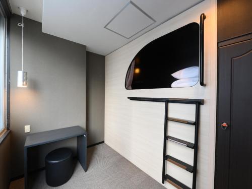 a small room with a desk and a window at The Centurion Sauna Rest & Stay Sapporo Male Only in Sapporo