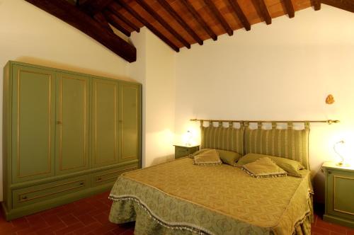 Un dormitorio con una cama y un armario verde. en Agriturismo Castello Di Querceto, en Lucolena in Chianti
