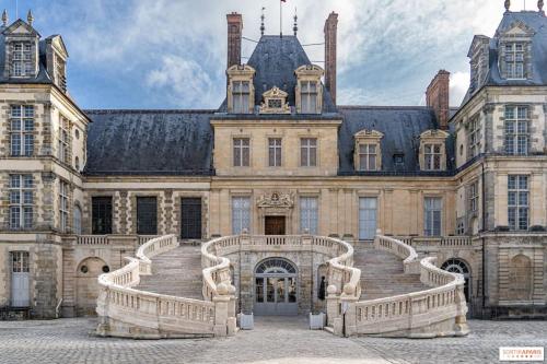 a large building with stairs in front of it at L'IMPASSE, T2 neuf et bien équipé, plein coeur de Maincy in Maincy