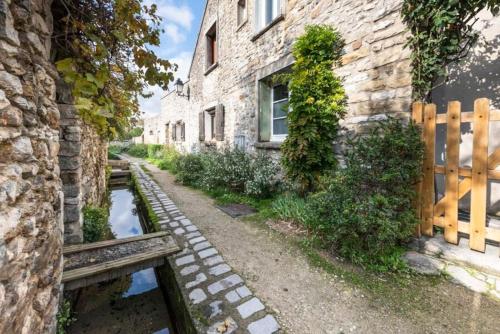 a stone building with a pond in front of it at L'IMPASSE, T2 neuf et bien équipé, plein coeur de Maincy in Maincy