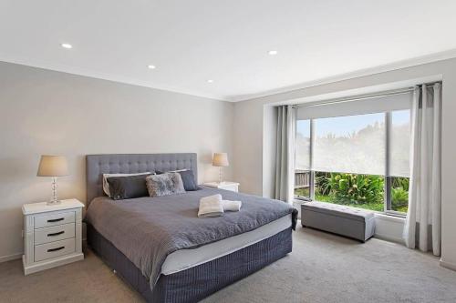 Un dormitorio con una cama grande y una ventana grande. en Cowes Island Retreat, en Cowes