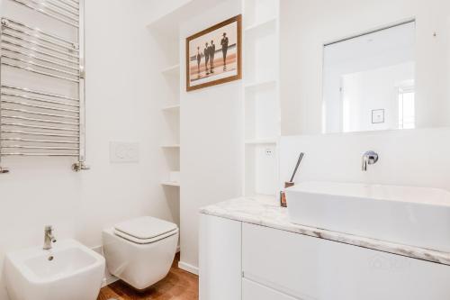a white bathroom with a sink and a toilet at Casa Jordan 47 in Rome