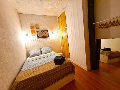 une petite chambre avec un lit dans une pièce dans l'établissement Appartement Coeur de Cité Vauban Briançon 51m2, à Briançon