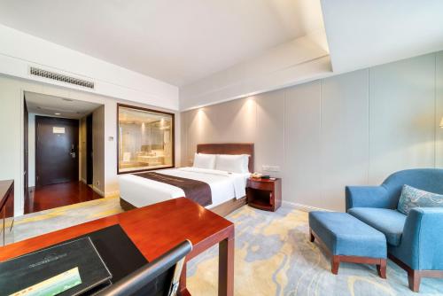a hotel room with a bed and a desk and a chair at Haiwaihai Nachuan Hotel Wanda Plaza Dujiaqiao Subway Station in Hangzhou