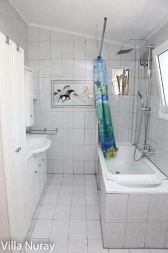 a white bathroom with a shower and a sink at Villa Nuray in Keramoti