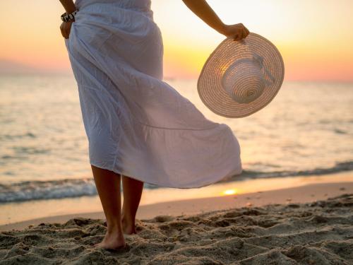 a woman walking on the beach with a straw hat at VACATION MARBELLA I Casa Isabel, Private pool with infinity views, BBQ, New Built, Luxury Condo, Top Location in Marbella