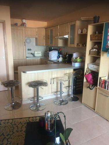 - une cuisine avec deux tabourets de bar au milieu dans l'établissement Pieds dans l eau, à Grosseto-Prugna