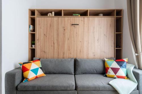 a gray couch with colorful pillows in a living room at Lake Suite, Self Check-In by HM in Gmunden
