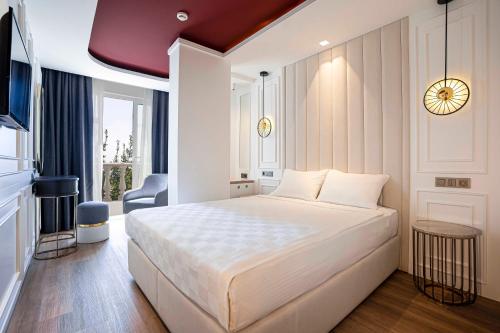 a bedroom with a large white bed and a window at La Boutique Hotel & Suites - Adults Only in Antalya