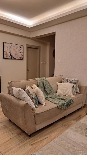 a brown couch with pillows in a living room at LeR Homes in Nairobi