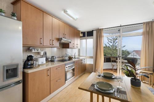 a kitchen with wooden cabinets and a table with plates on it at Vivir Bajamar in Bajamar