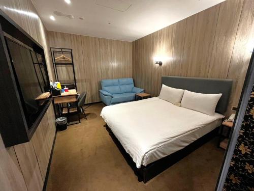 a bedroom with a bed and a blue chair at Airline Inn Ximen in Taipei