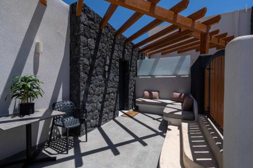 a patio with a stone wall at LyMaRou Collection in Megalokhori