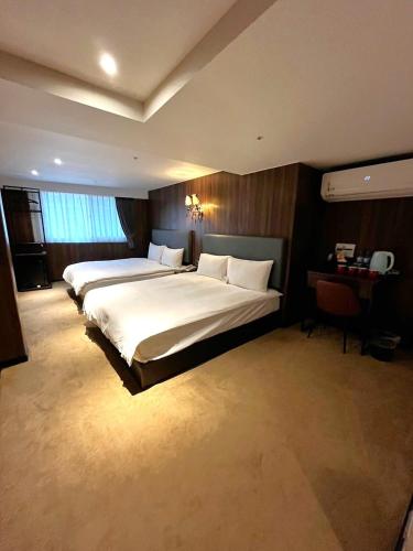 a hotel room with two beds and a desk at Airline Inn Ximen in Taipei