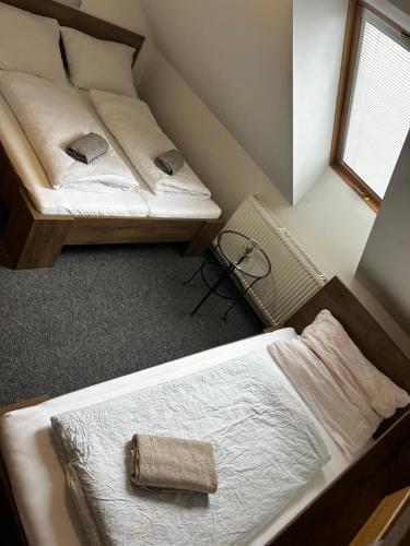 a room with two beds and a window at Restaurace a penzion Na Stráni in Klášterec nad Orlicí