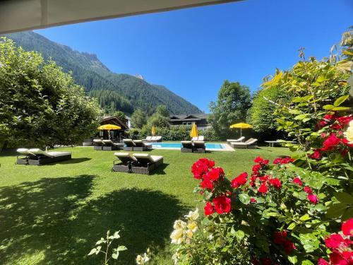 a garden with flowers and a swimming pool at Alpenhotel Tirolerhof in Neustift im Stubaital