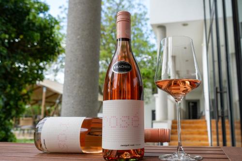a bottle of wine and a glass on a table at KRACHER Apartment No 1 - inklusive Pool in Illmitz