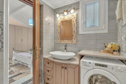 a bathroom with a washing machine and a sink at Stella's House in Lefkada Town