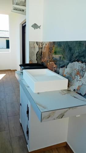 a white desk in a room with a painting at Marija šimičić in Rab