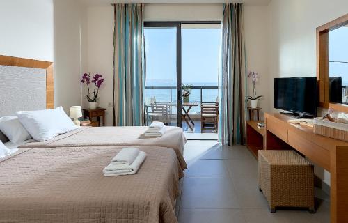 a hotel room with two beds and a television at Creteco Hotel & Suites in Gournes