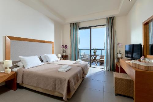 a bedroom with a large bed and a television at Creteco Hotel & Suites in Gournes