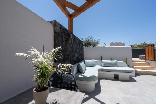 a patio with a couch and a table and chairs at LyMaRou Collection in Megalokhori