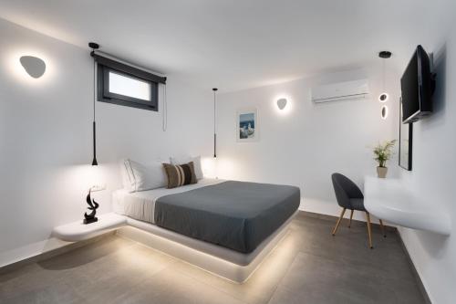 a bedroom with a bed and a desk and a television at LyMaRou Collection in Megalokhori