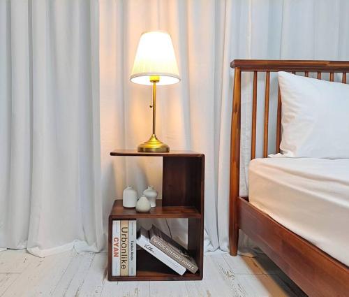 a lamp on a night stand next to a bed at HaengGung MaSil in Suwon