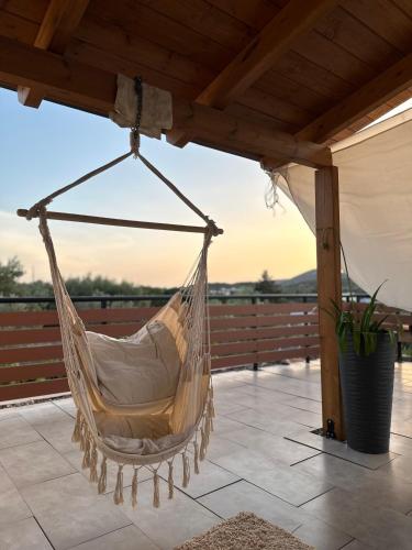 a hammock hanging from a pergola on a patio at Boomers Attic Athens in Koropíon